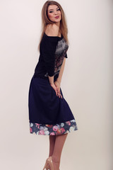 Fototapeta premium Young brunette lady in black dress posing on grey background