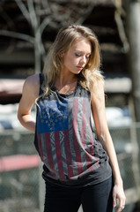 Obraz na płótnie Canvas Blonde women is wearing a top featuring the stars and stripes