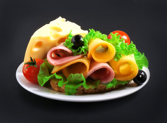 sandwich with vegetables, herbs, cheese and spices on a plate