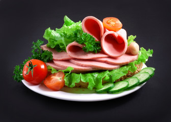 sandwich with vegetables, herbs and spices on a white plate