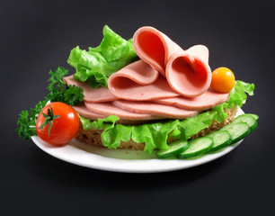 sandwich with vegetables, herbs and spices on a white plate