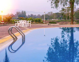 Luxury swimming pool with plam tree in morning
