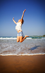 Woman Jumping In The Air On Tropical Beach