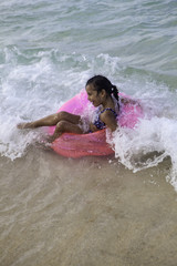 little girl floating on a pink raft