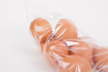 Eggs in a plastic bag on white paper background