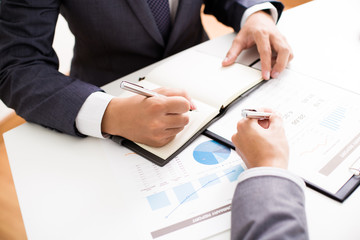 Two businessmen looking at report and having a discussion in off