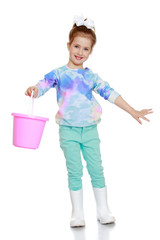funny little girl in rubber boots and bucket in hand