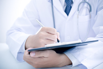 Fototapeta premium Close-up Of Male Doctor Filling The Medical Form