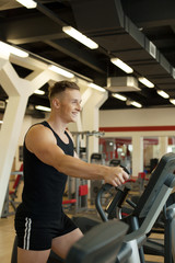 Fototapeta na wymiar Merry young man exercising on treadmill