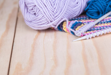 needles and skeins of yarn on a wooden table