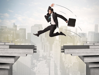 Energetic business man jumping over a bridge with gap