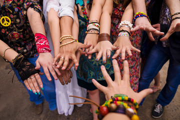 Many hands in bracelets with bright manicure