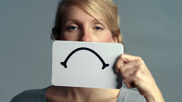 Woman Closeup showing her Emotions Using A piece of Cardboard