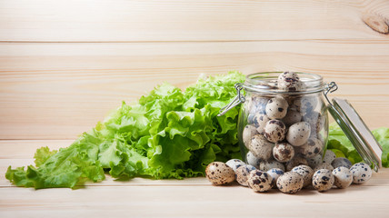 Quail eggs in a glass jar and a green salad