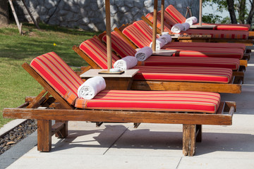 Sun loungers with towels near the swimming pool. Thailand