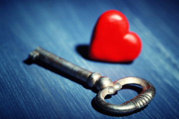 Retro key with red heart on color wooden table background