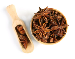Star anise in wooden bowl, isolated on white