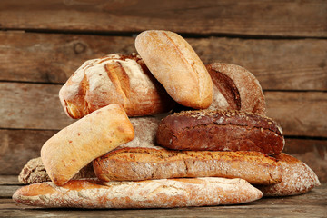 Different fresh bread on old wooden table