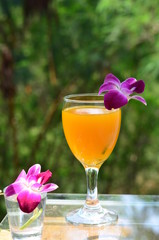 Orange juice in glass, fresh fruits on wooden background