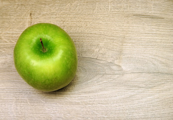 Green apple on the wooden background