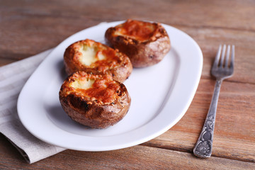 Baked potatoes on pate on wooden table