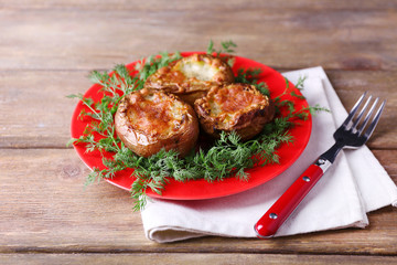Baked potatoes with dill on pate on wooden table