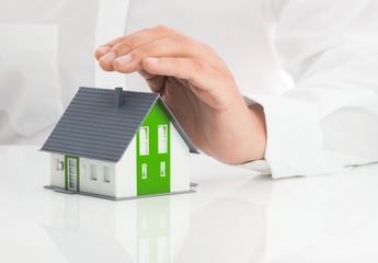 Immobilienberater hält seine Hand über Einfamilienhaus