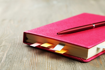 Notebook with bookmarks on wooden table