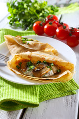 Pancakes with creamy mushrooms and greens in plate