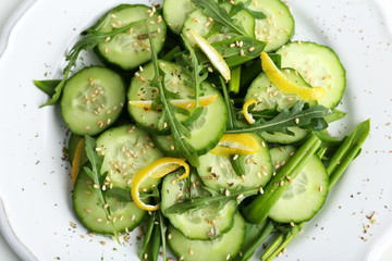Green salad with cucumber, arugula and lemon peel, closeup