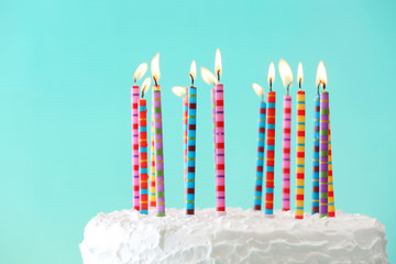 Birthday cake with candles on color background