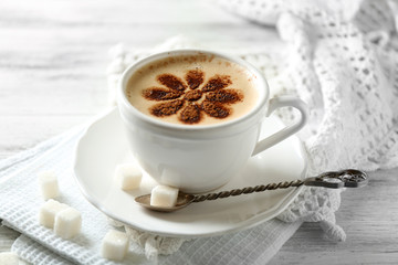 Cup of latte coffee art on wooden table, on light background