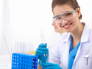 Woman researcher is surrounded by medical vials and flasks