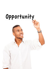 African smiling man is writing the word opportunity with pen ove