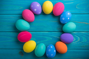 easter colored eggs with lace ribbon on blue wooden background