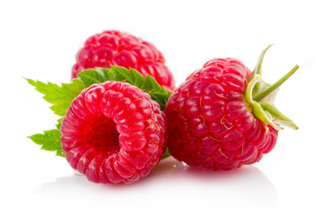 Ripe red raspberries with green leaves isolated on white
