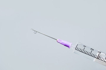 Hypodermic needle ejecting clear liquid - isolated syringe