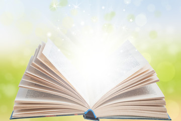 Open magic book with light