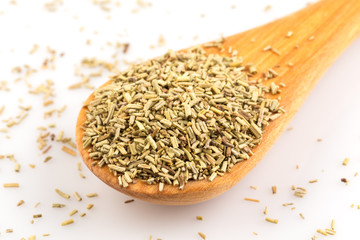 Dried rosemary leaves in wooden spoon