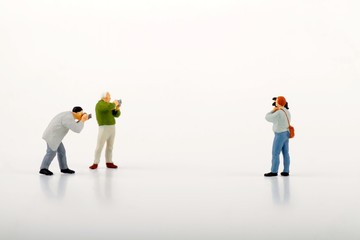 miniature figurines of photographers and cameraman on a white background