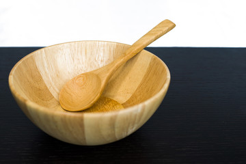 Empty wooden dish and spoon on dark table isolated on white back