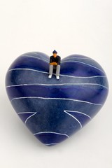 miniatura di uomo solitario su un cuore