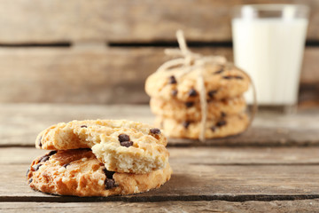 Tasty cookies and glass of milk on rustic wooden background