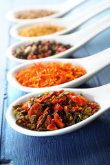Different kinds of spices in ceramics spoons, close-up,