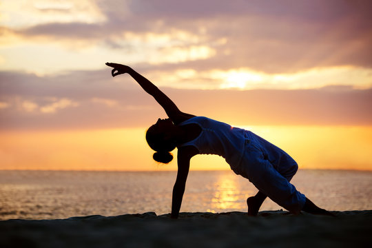 Caucasian woman practicing yoga at seashore