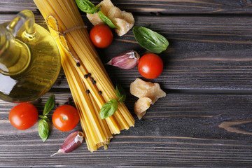 Raw pasta with cheese and vegetables on wooden background