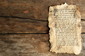 Grunge paper with hieroglyphics on wooden background