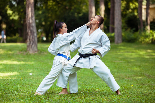 Two young people practicing martial arts outdoors