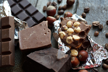 Set of chocolate with nuts on wooden table, closeup