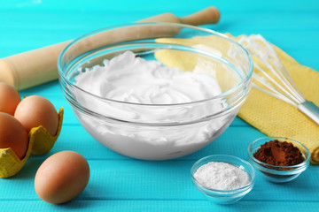 Whipped egg whites for cream on color wooden background